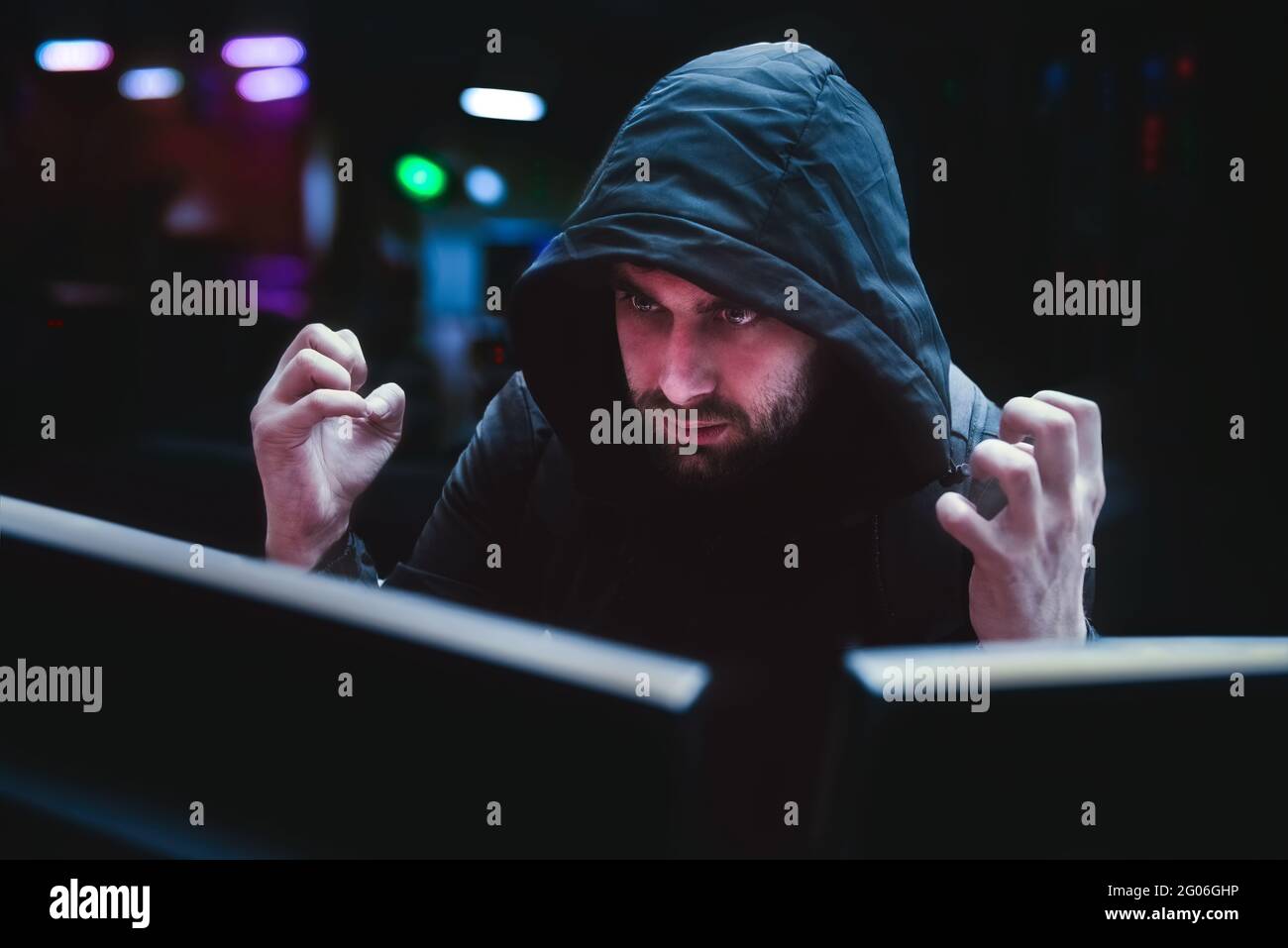 Un hacker maschio sperimenta emozioni arrabbiate su un hack fallito, il concetto di un hack. Un hacker astuzia in attesa di un hack di sistema riuscito Foto Stock