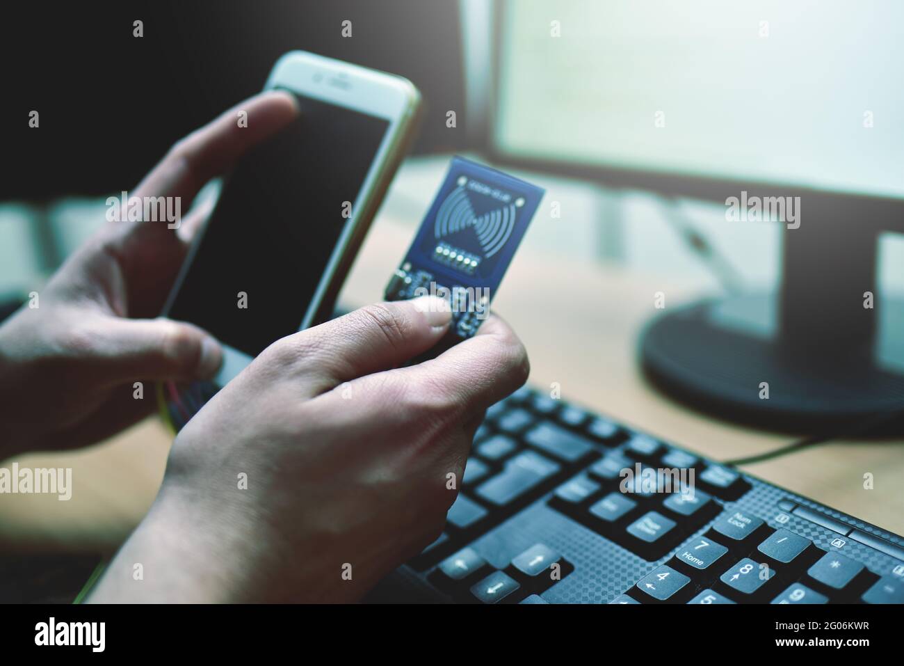 Il hacker maschile sta tentando di accedere al telefono. Sicurezza e protezione dei dati personali. Il concetto di criminalità informatica e hacking di dispositivi elettronici Foto Stock