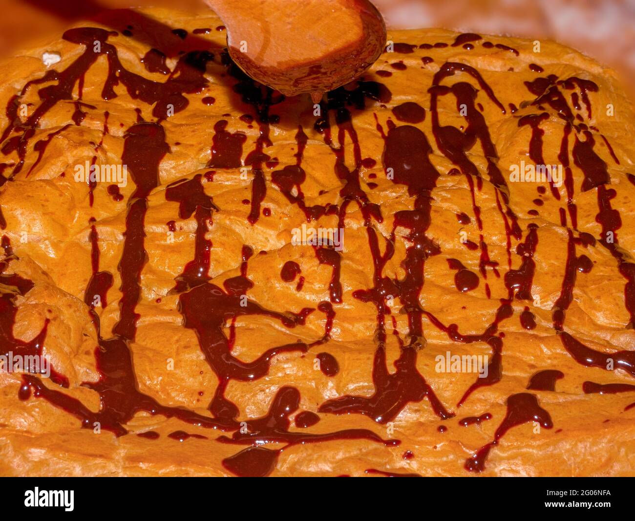 Gocciolamento di cioccolato sulla superficie della torta fatta in casa di puff grande (Profiterole grande) Foto Stock