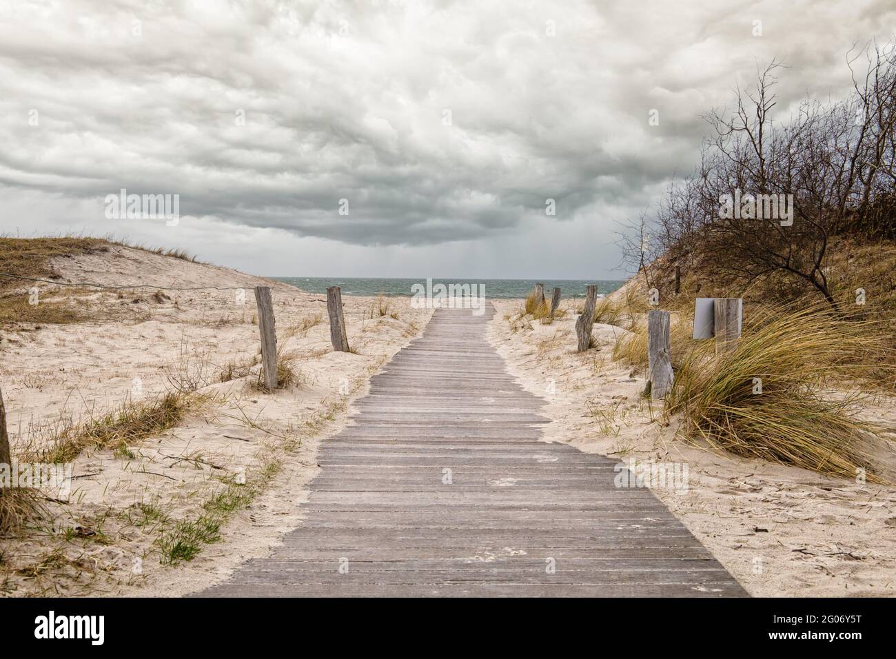 Percorso per la spiaggia baltica in legno con dune e cielo nuvoloso Foto Stock