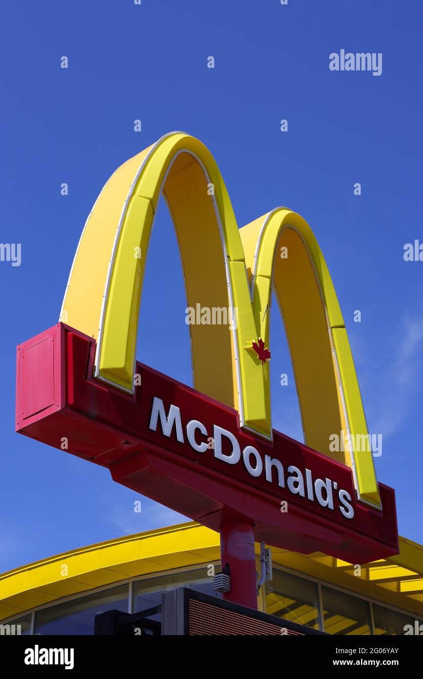 Ottawa, Ontario, Canada - 31 maggio 2021: Il logo McDonald's Golden Arches, con una foglia d'acero nella sua variante canadese, su un cartello presso un ristorante. Foto Stock
