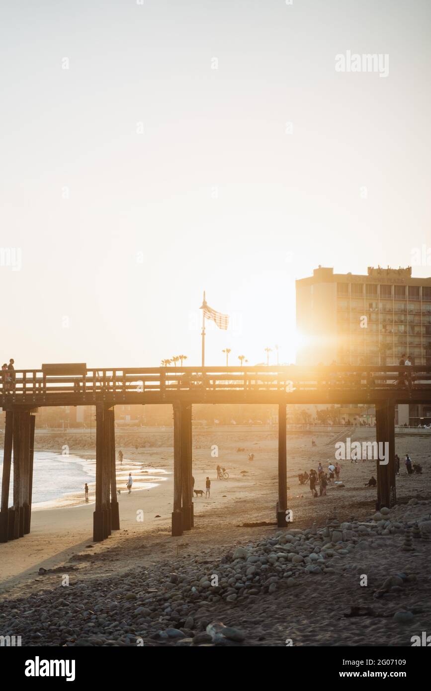 VENTURA, STATI UNITI - 31 maggio 2021: Bandiera americana sventolando su un molo a Ventura California con il sole che tramonta dietro di esso. Foto Stock
