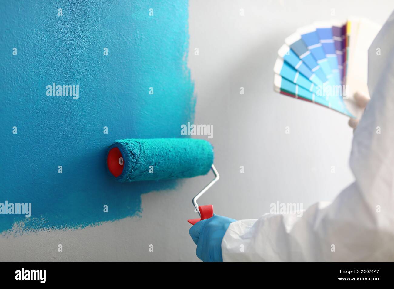 Il maestro pittore tiene in mano una tavolozza di colori con sfumature di blu Foto Stock