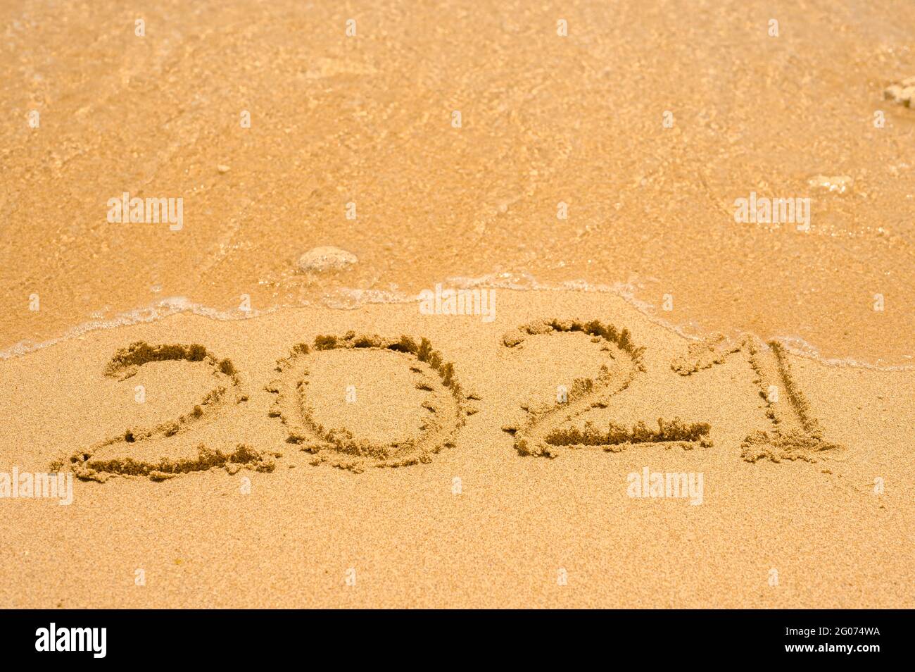 2021 caratteri numerici sulla spiaggia di mare, onda e luce dorata del tramonto. numero 2021 su perfetta spiaggia di sabbia tropicale. Concetto di vacanza di viaggio. Copia sp Foto Stock