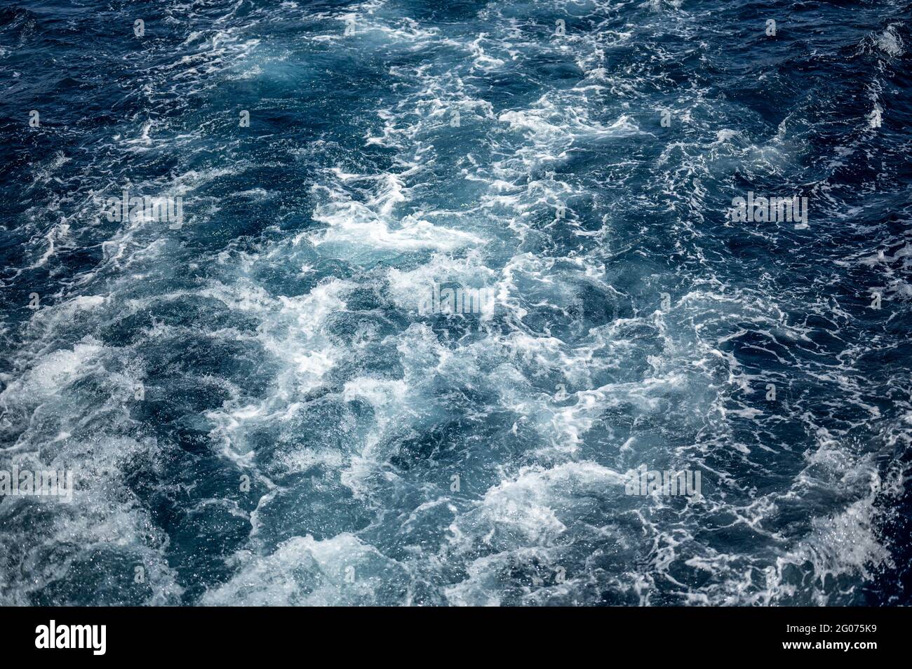 sveglia con acqua di mare, mare blu scuro e schiuma bianca, wake con acqua di mare, schiuma blu scuro e bianca. Acqua di mare blu texture Foto Stock