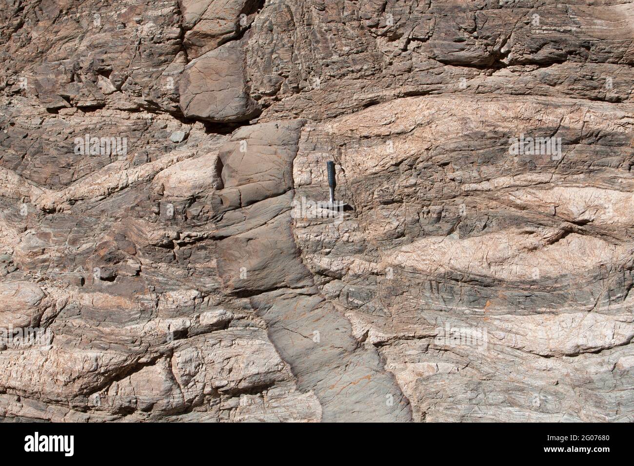 Dike basaltico con margini refrigerati intrusione nella roccia metamorfica (gneiss) e compensato da un piccolo difetto, se California. Martello da roccia per bilancia. Foto Stock