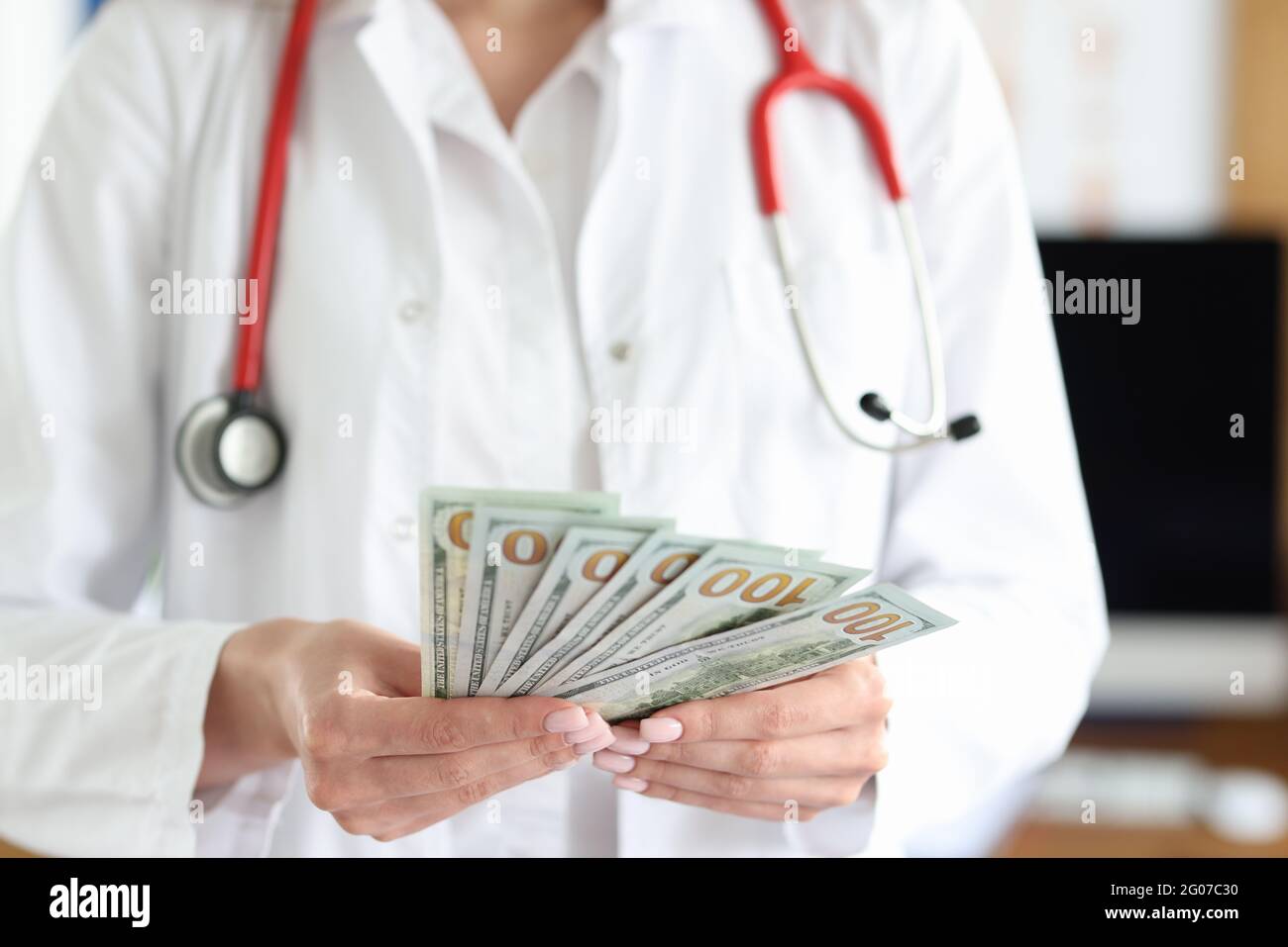 Il medico tiene le fatture del dollaro di contanti nelle sue mani Foto Stock