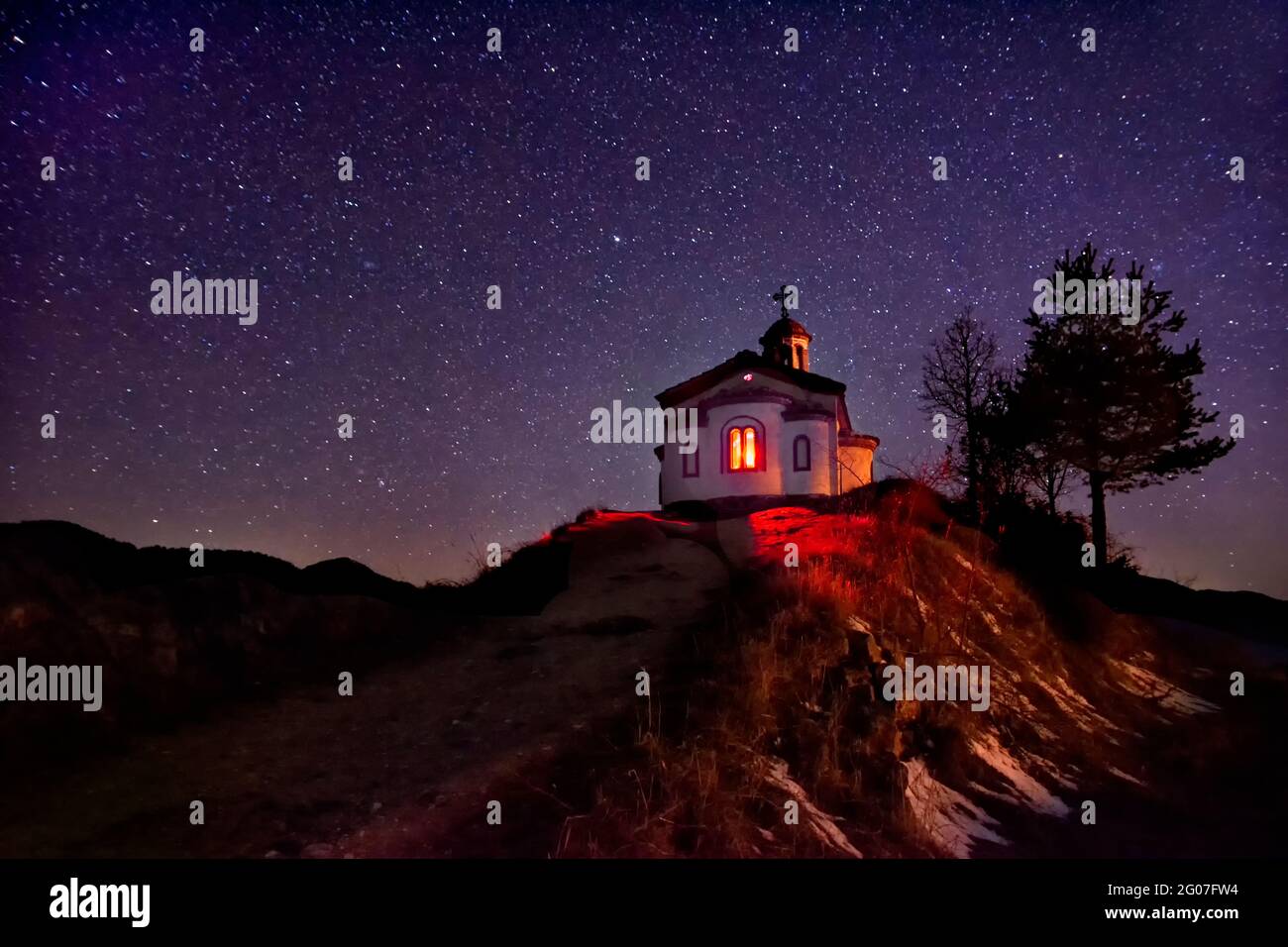 Piccola cappella sulla collina in montagna Rhodope vicino al villaggio di Borovo. Bulgaria.Night cielo stellato, blu spazio luminoso. Sfondo astratto con stelle,cosmo Foto Stock
