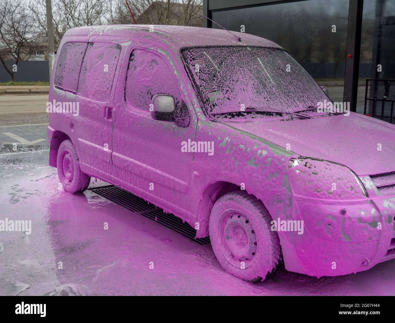 auto in schiuma rosa al lavaggio auto, donna si lava felicemente la sua auto  Foto stock - Alamy