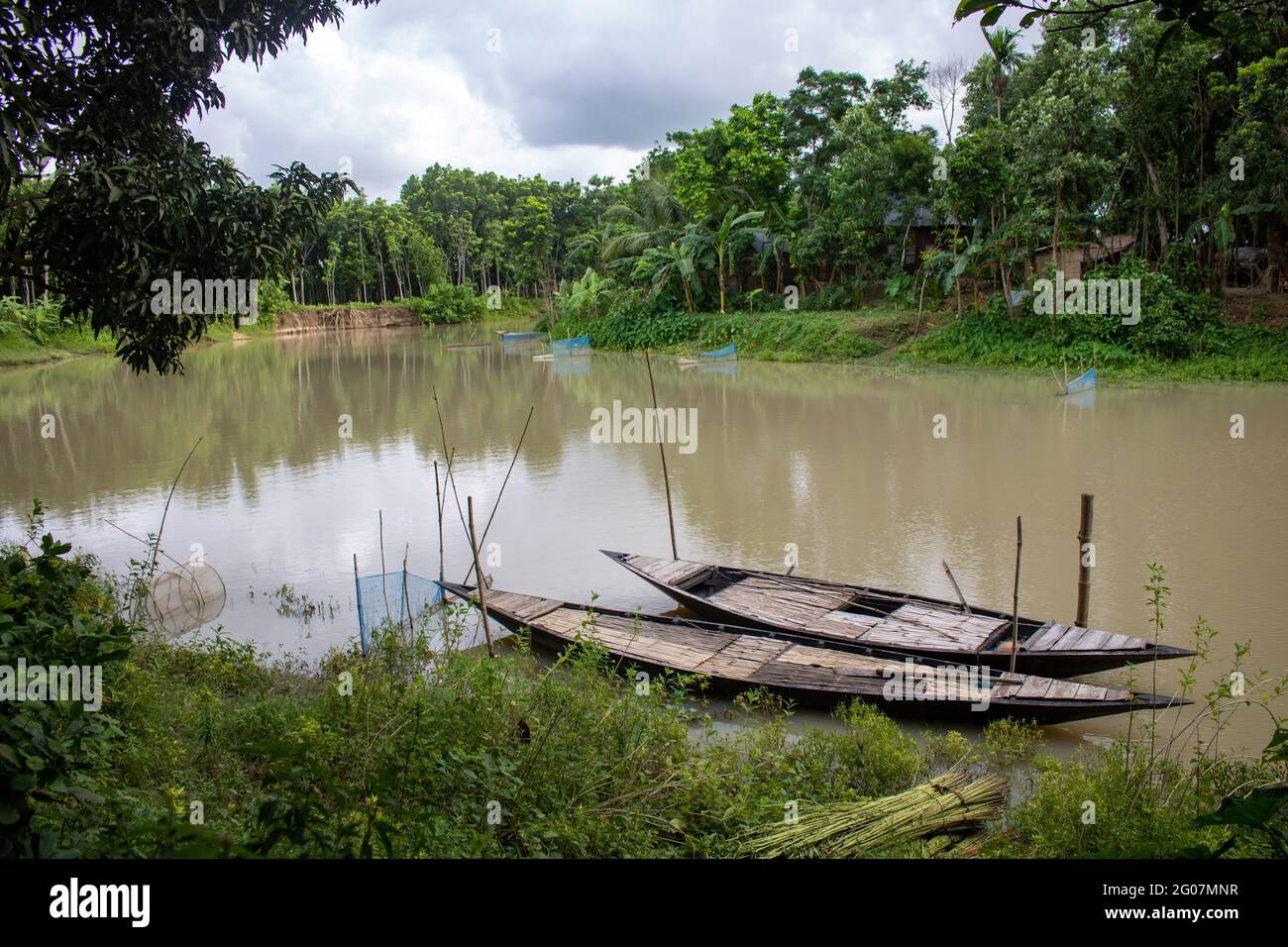 Il Bangladesh è un paese fluviale. Un piccolo fiume tranquillo e bello. Ci sono due barche legate al molo. Foto Stock