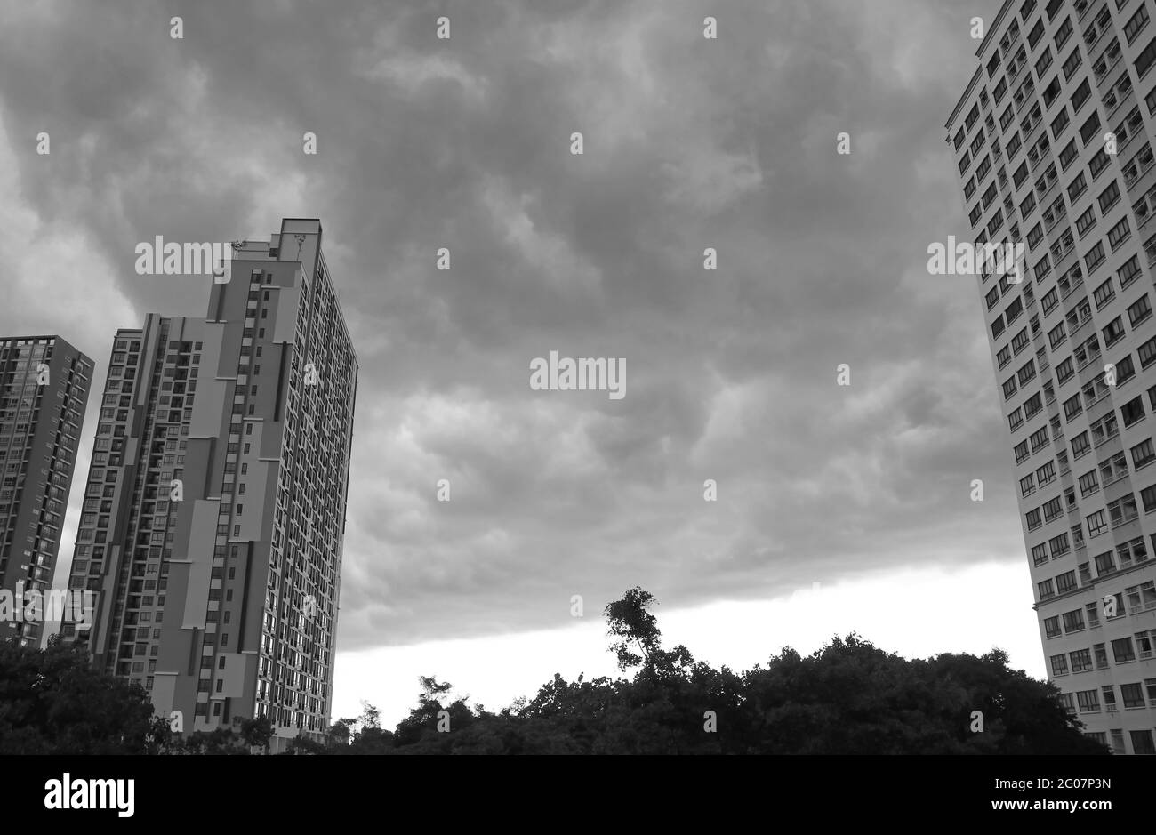 Incredibili nuvole nimbus grigio scuro sopra i grattacieli prima della pioggia pesante in monocromia Foto Stock