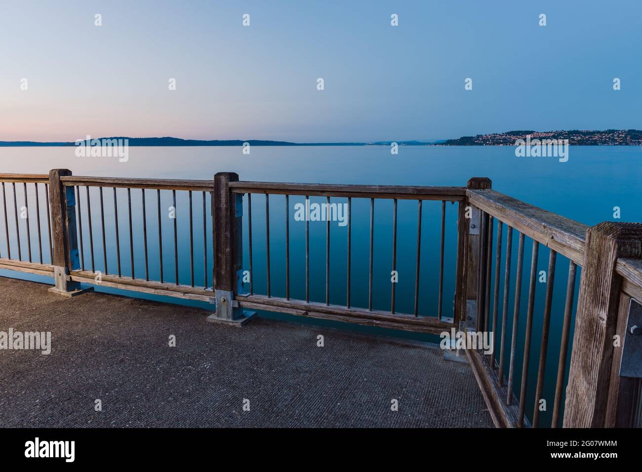 Blue Hour sul molo con vista sulle acque tranquille e tranquille Foto Stock