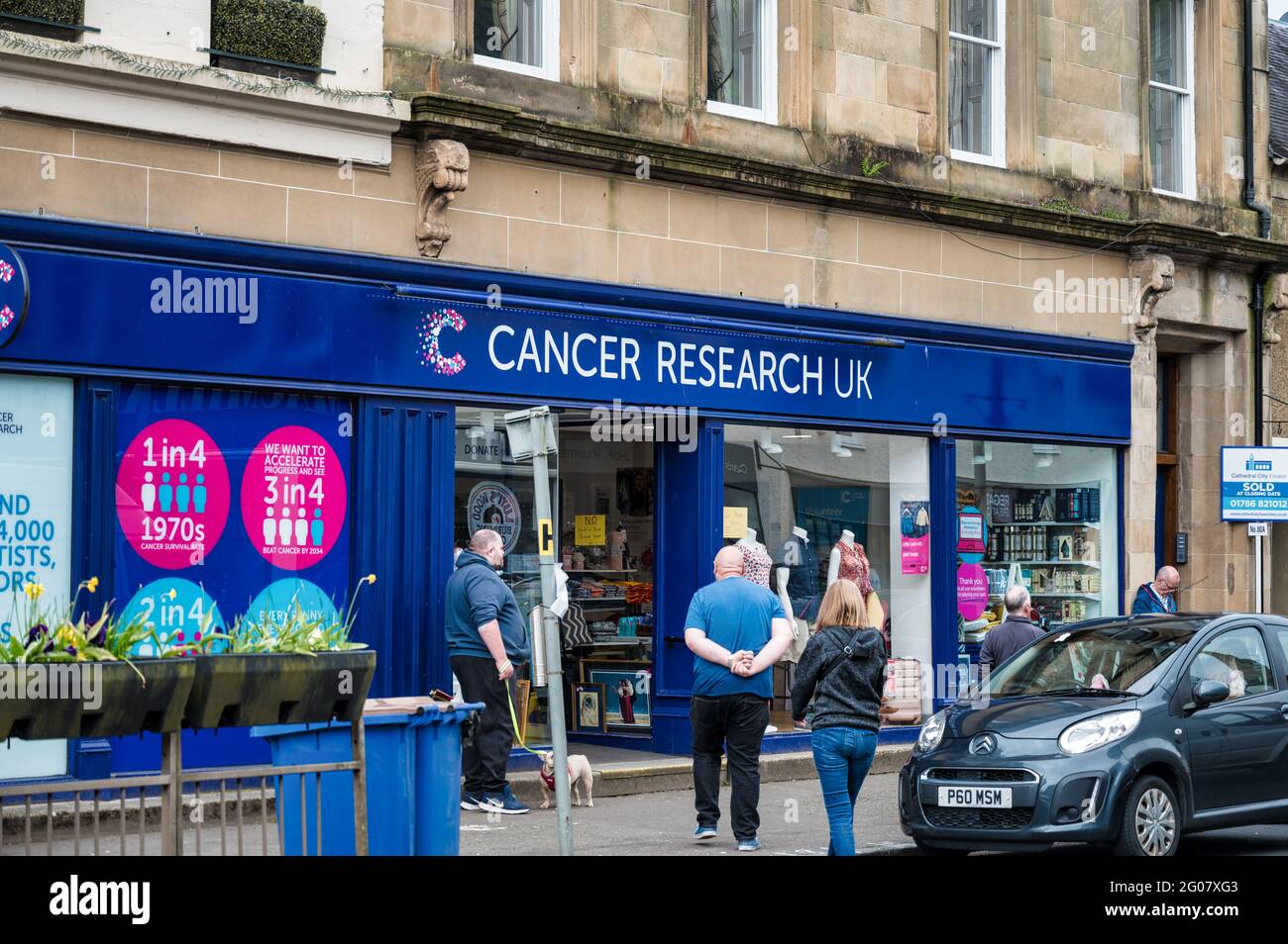 Callander, Scozia - 29 maggio 2021: Il fronte del negozio e segno per Cancer Research UK Foto Stock