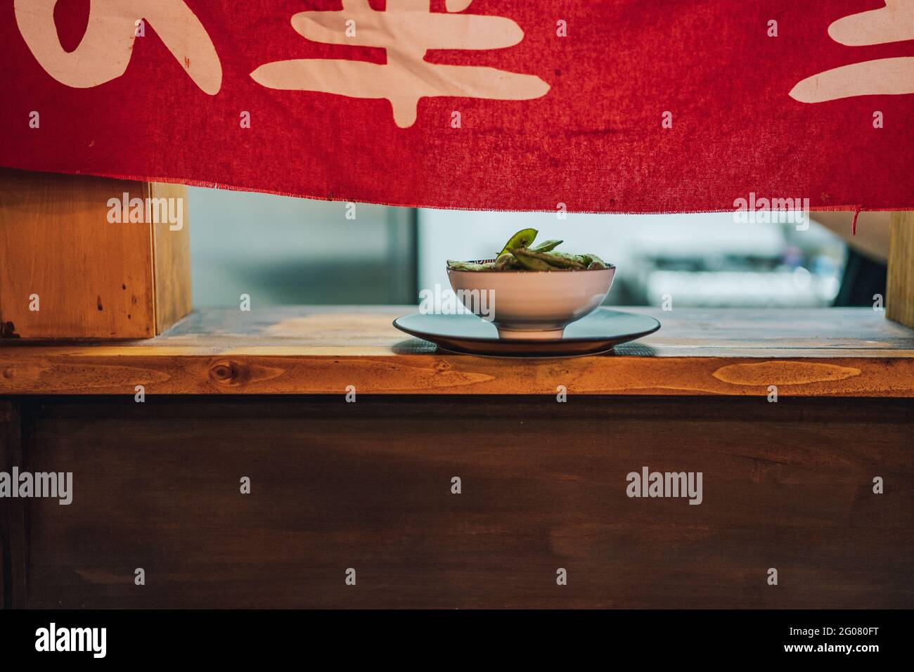 Piatto asiatico tradizionale in ciotola bianca in ceramica su finestra di legno nel ristorante Foto Stock