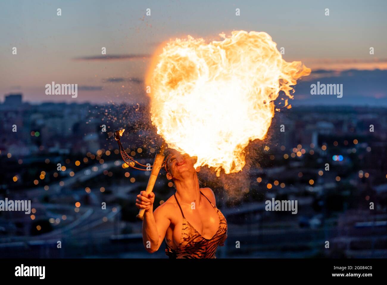 Fire-Eater Woman che esegue Spit Fire al tramonto Foto Stock