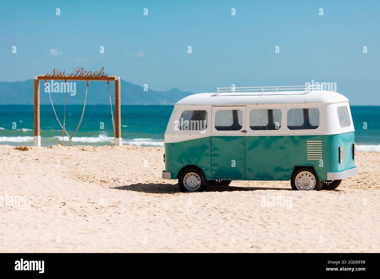Splendida vista sulla spiaggia con arco in legno e hippie bus Foto Stock