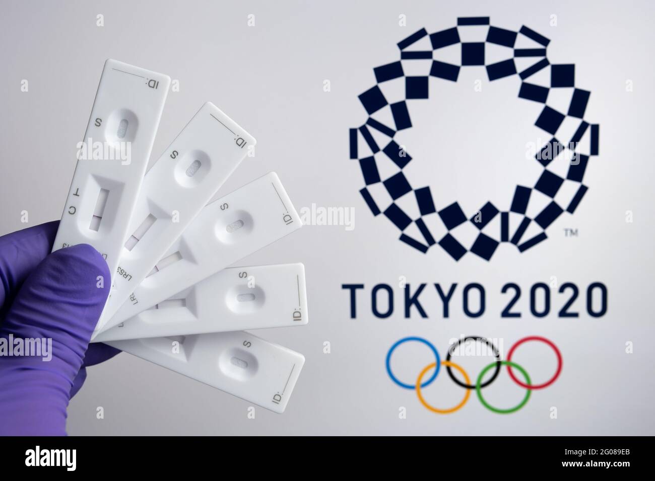 Test PCR negativi davanti e logo Tokyo 2020 offuscato sullo sfondo offuscato. Concetto per i giochi olimpici COVID di Tokyo nel 2021. Stafford, United Kin Foto Stock