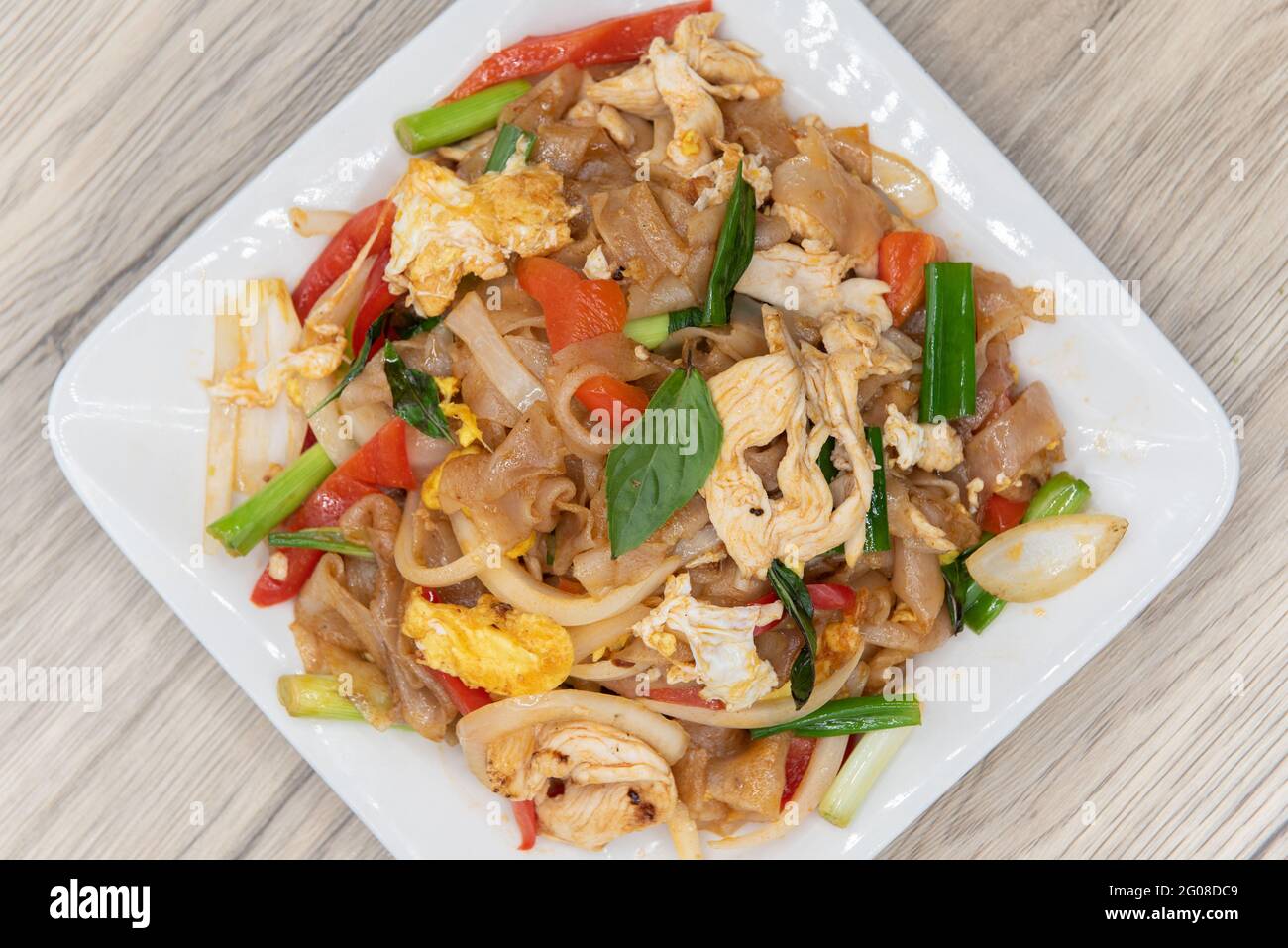 Vista dall'alto dei grandi tagliatelle, frittura con basilico su un mucchio di verdure per un delizioso sapore tailandese piccante. Foto Stock