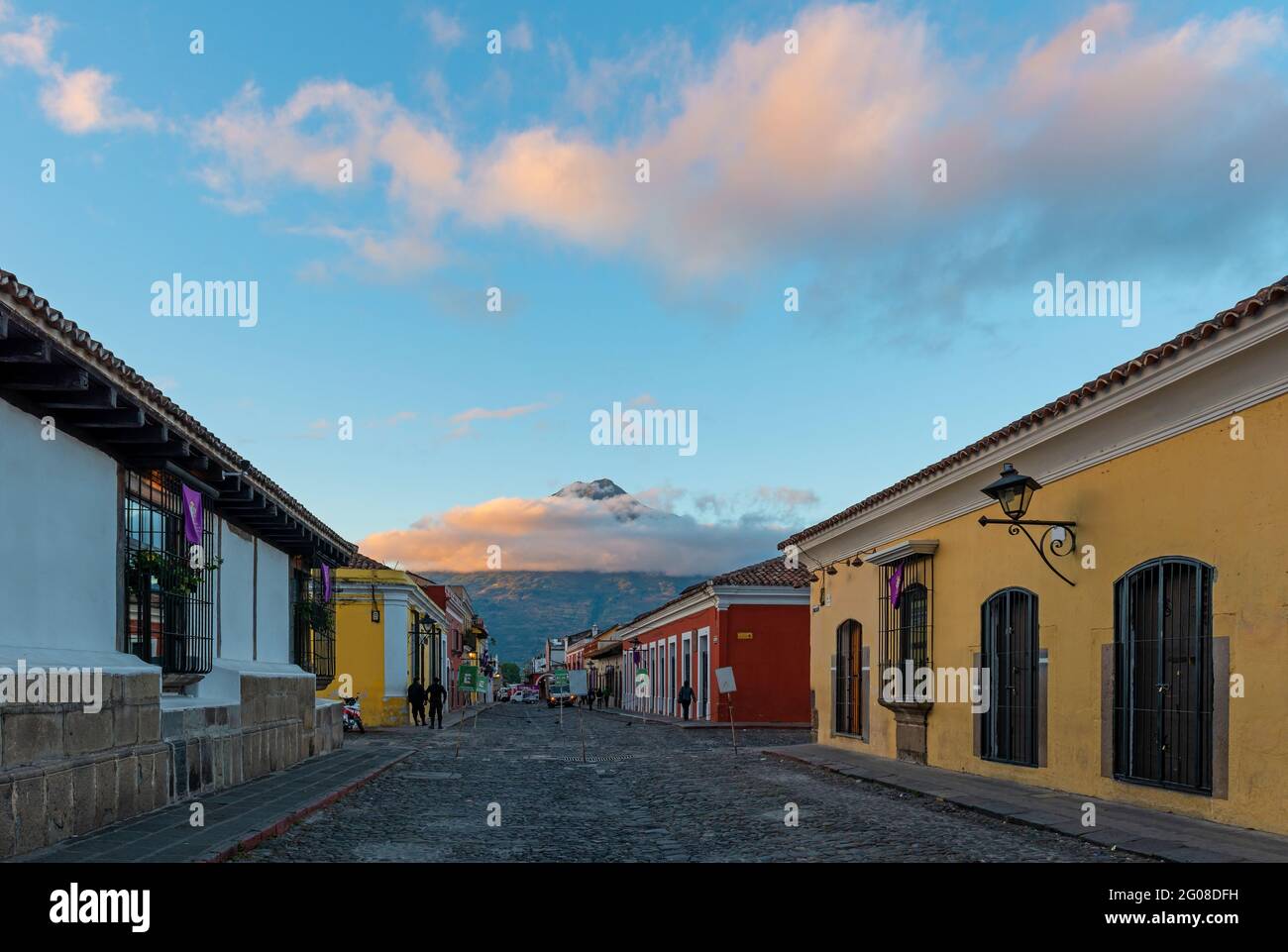 Antigua strada della città all'alba con il vulcano Agua, Guatemala. Foto Stock