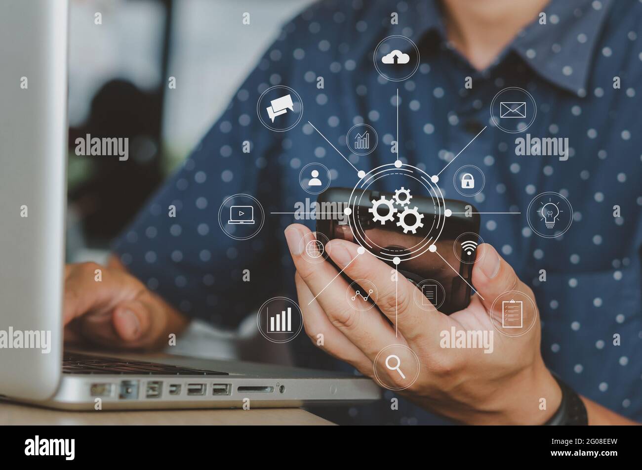 Uomo che lavora con il telefono cellulare e computer laptop business social network e comunicazione online.Digital marketing media app mobile in icona virtuale Foto Stock