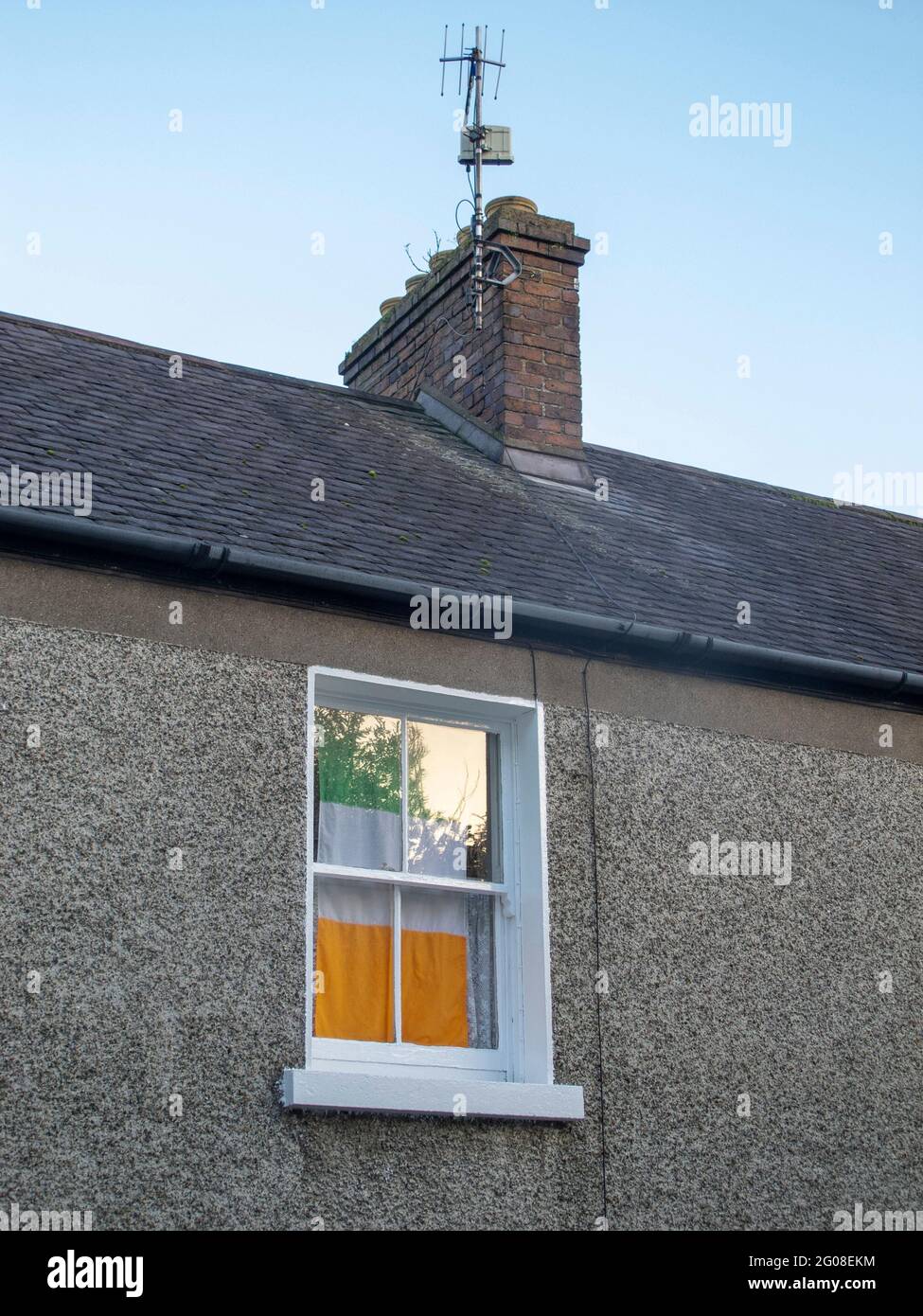 Un tricolore irlandese è appeso in una finestra residenziale a Carlingford County Louth Irlanda Foto Stock