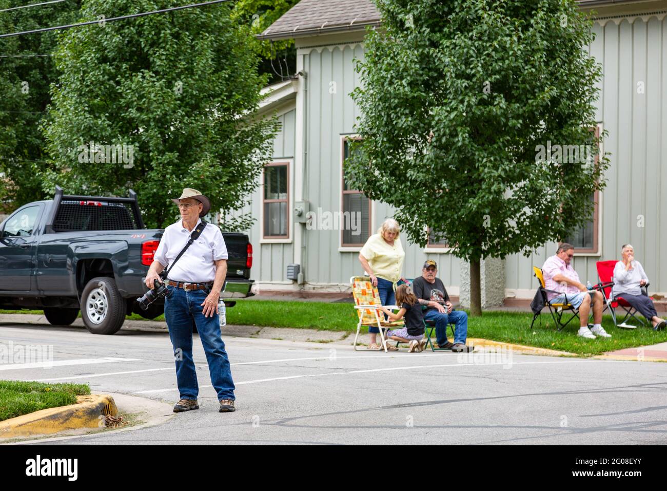 Un uomo con una macchina fotografica guarda verso i partecipanti alla sfilata durante il Festival Auburn Cord Duesenberg 2019 ad Auburn, Indiana, USA. Foto Stock