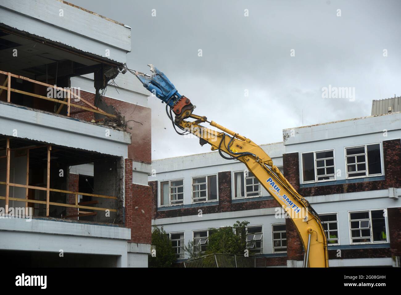 GREYMOUTH, NUOVA ZELANDA, 19 gennaio 2021: Un escavatore utilizza un attacco a artiglio per demolire il vecchio edificio ospedaliero a Greymouth, Nuova Zelanda, gennaio Foto Stock