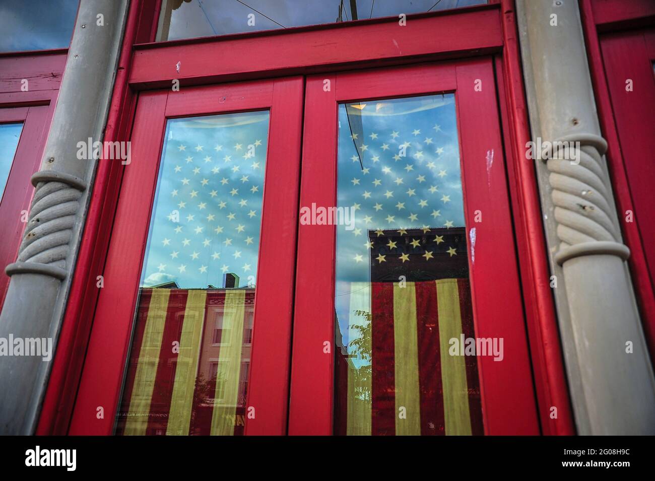 La bandiera americana in una porta di una piccola impresa nel Midwest rurale Foto Stock
