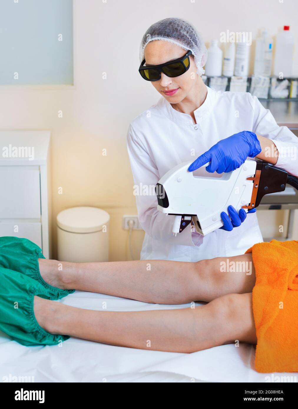 Cliente femminile che fa la rimozione dei capelli del laser dalle gambe Foto Stock