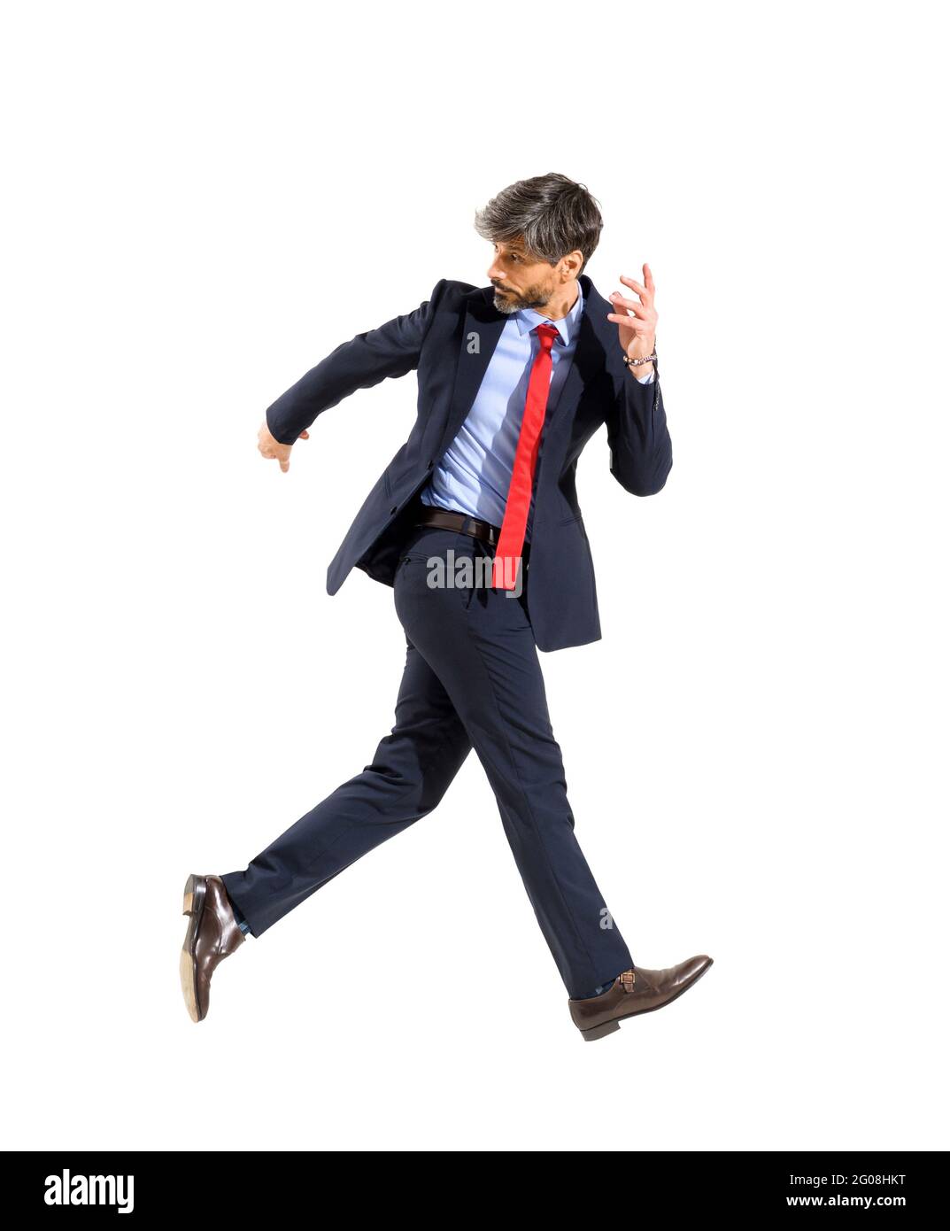 Uomo d'affari di successo giubilante che cammina in aria guardando indietro sopra la sua spalla in un'immagine concettuale dell'idioma isolato sopra uno studio bianco Foto Stock