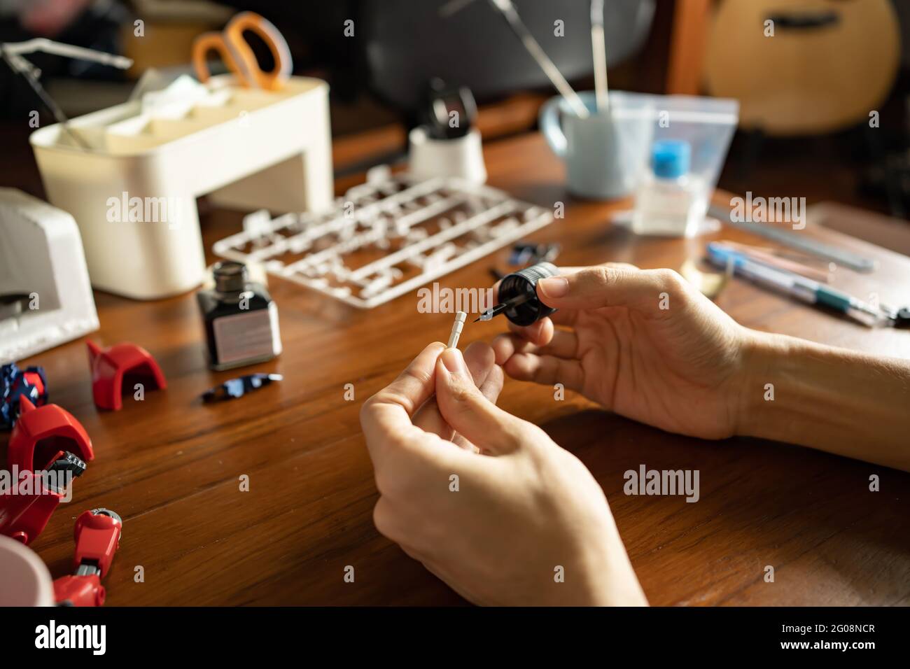 Un uomo che dipinge vernice smalto su un kit di modelli in plastica Foto Stock