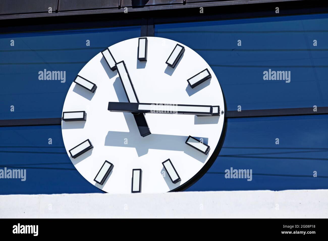 Hornefors, Norrland Svezia - 10 maggio 2021: Un grande orologio bianco con le mani sulla costruzione della stazione Foto Stock