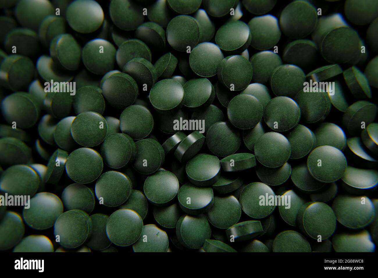 Spirulina verde pillole sfondo. Spirulina alghe verde compresse.Super cibo. Integratori alimentari per uno stile di vita sano Foto Stock
