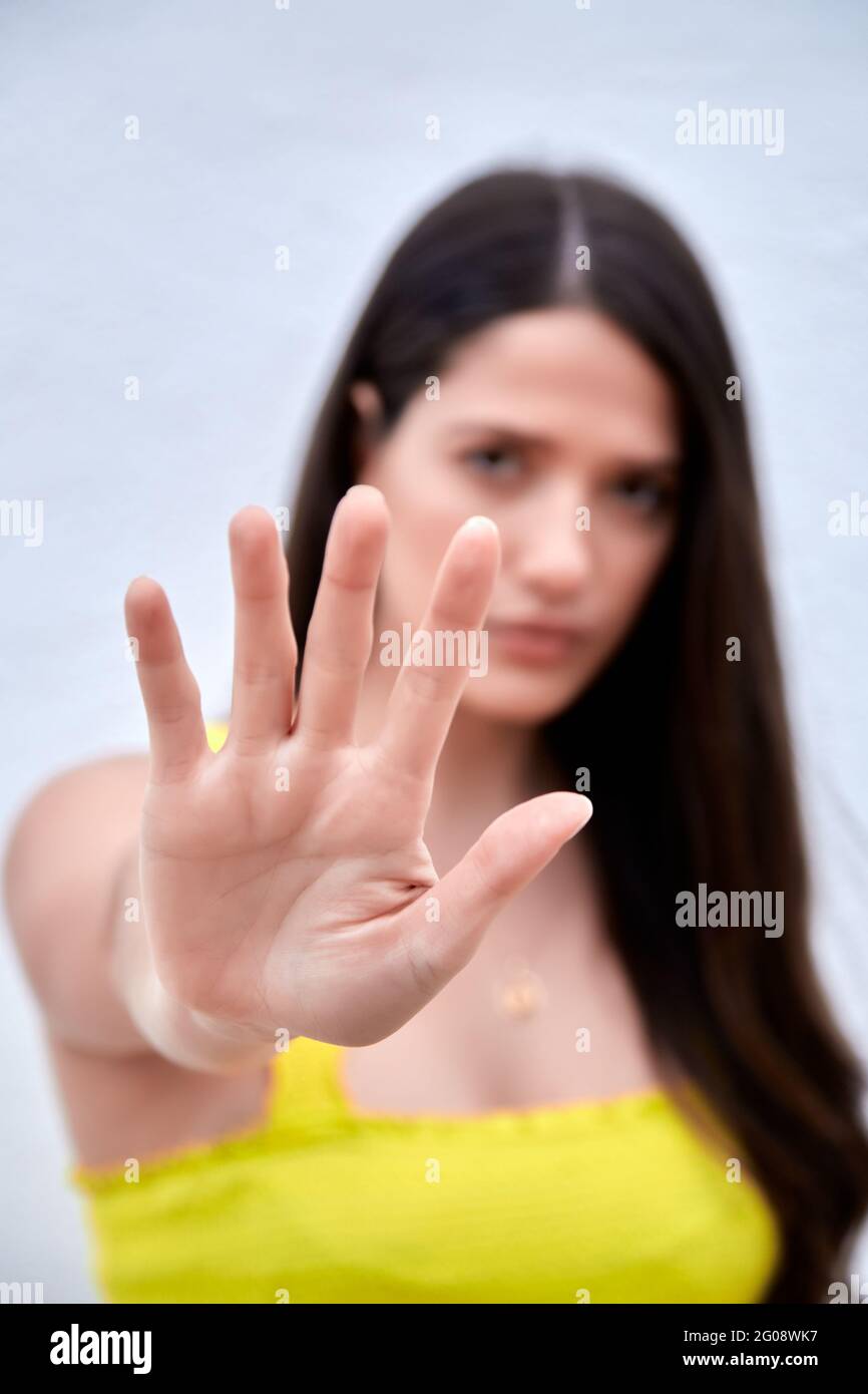 Primo piano di una giovane donna che mostra il gesto di stop con la mano che dice di no alla violenza domestica o all'abuso, protesta femminile contro l'aborto o la discriminazione, concetto di linguaggio non verbale. Foto di alta qualità. Foto Stock