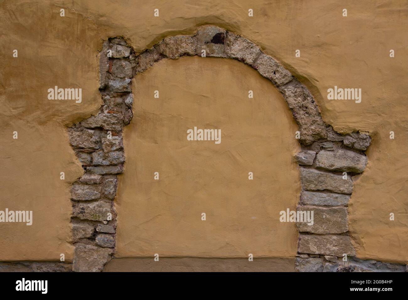 Arco di pietra naturale in una parete di colore arancione con spazio copia Foto Stock