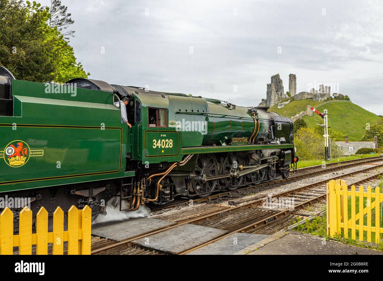 34028 Eddystone, una locomotiva a vapore del 1946 brocche dalla stazione ferroviaria del castello di Corfe Dorset England UK in un giorno di primavera brillante Foto Stock