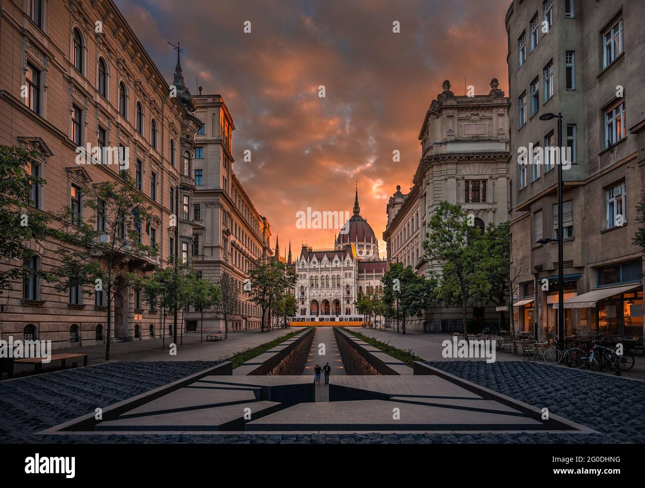 Budapest, Ungheria - il memoriale dell'unità nazionale e del Parlamento dell'Ungheria con il tradizionale tram giallo e il cielo e le nuvole del tramonto Foto Stock