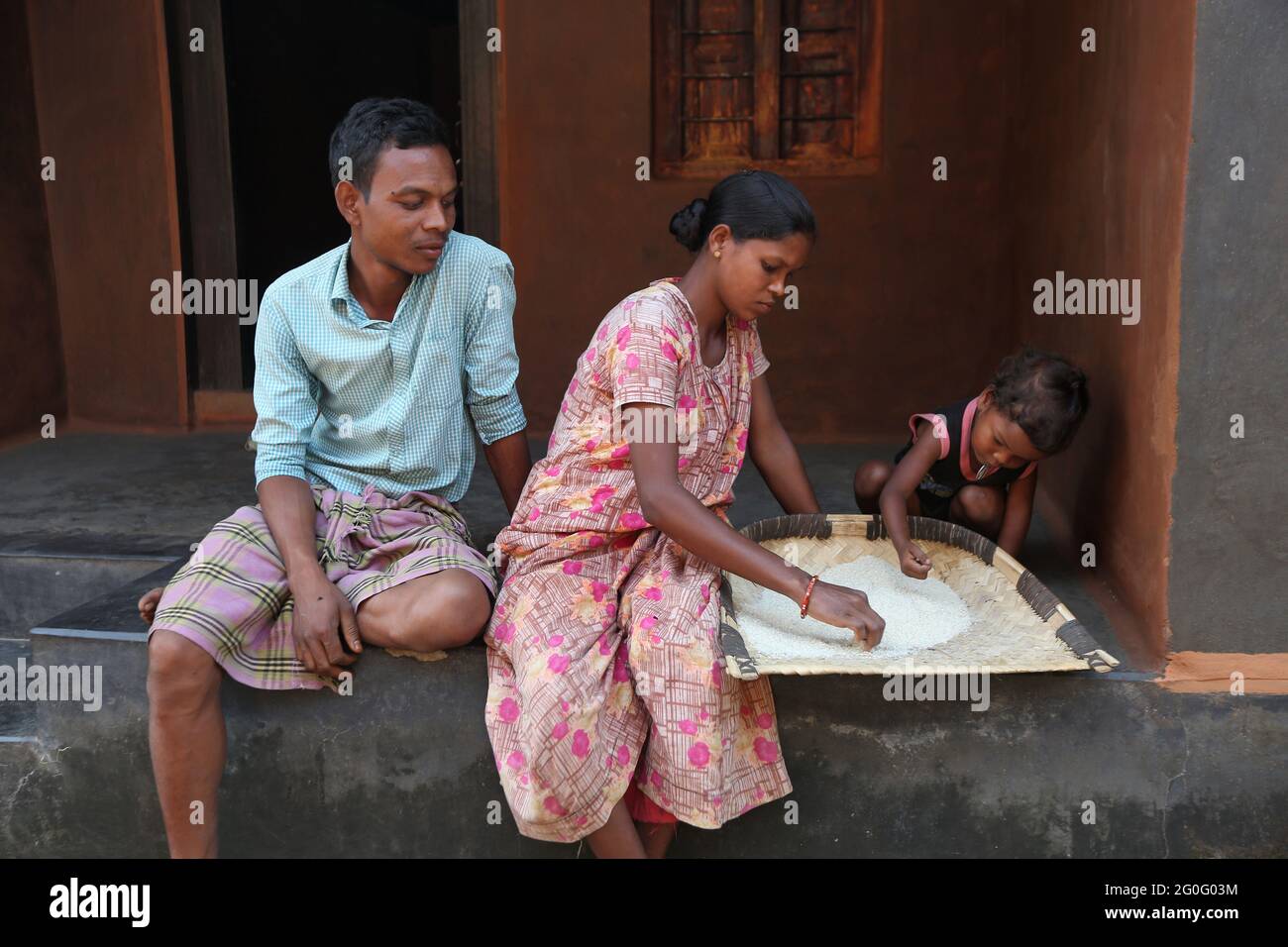 TRIBÙ LANJIA SAORA. Coppia e bambino. Nella foto si vede anche la tradizionale padella da vino. Gunpur Villaggio di Odisha, India Foto Stock