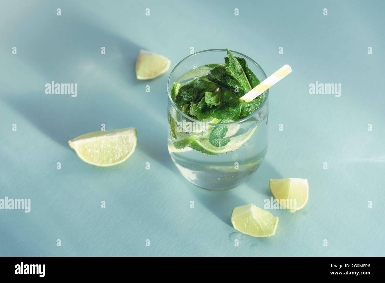 Mojito bere con la paglia sul tavolo blu. Bevanda rinfrescante fredda con fette di menta e limone, vista dall'alto. Foto Stock