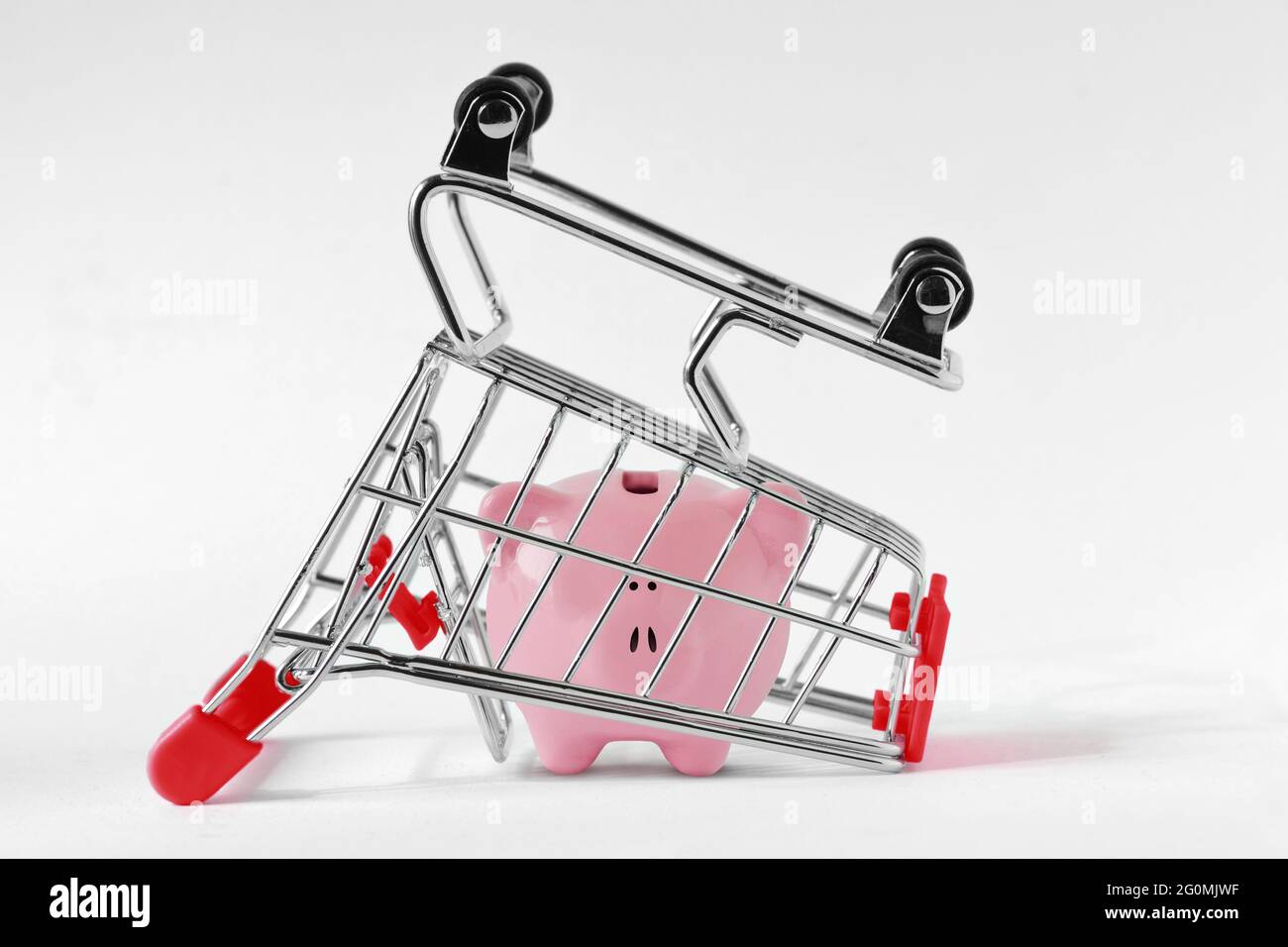 Piggy bank sotto il carrello capovolto - concetto di risparmio di denaro e shopping Foto Stock