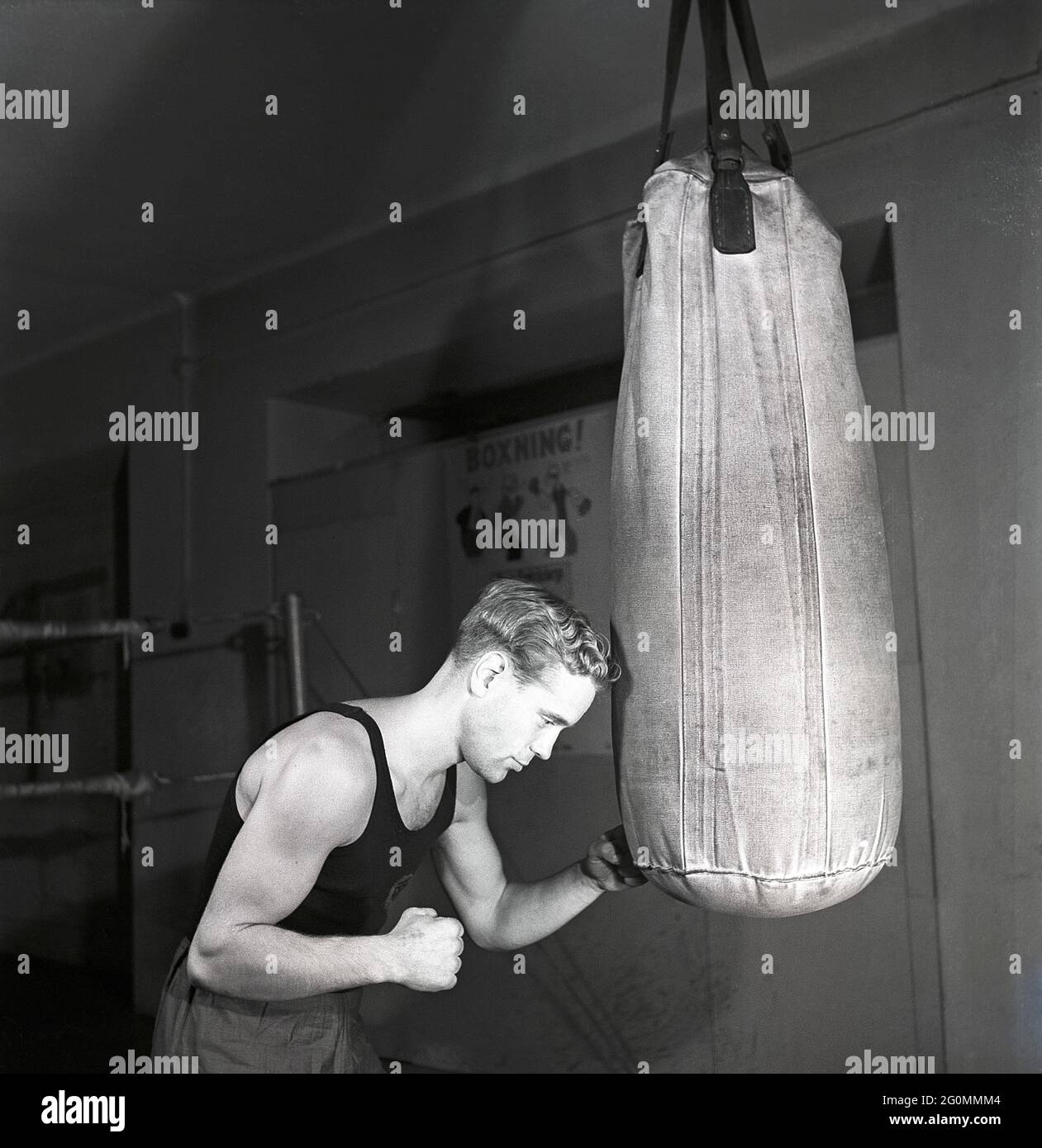 Boxer negli anni '40. Un giovane che lavora fuori durante l'addestramento di boxe. Viene raffigurato pugilato il sandbag appeso al tetto, un modo tradizionale di addestramento alla boxe. Svezia 1944 rif. K115-3 Foto Stock
