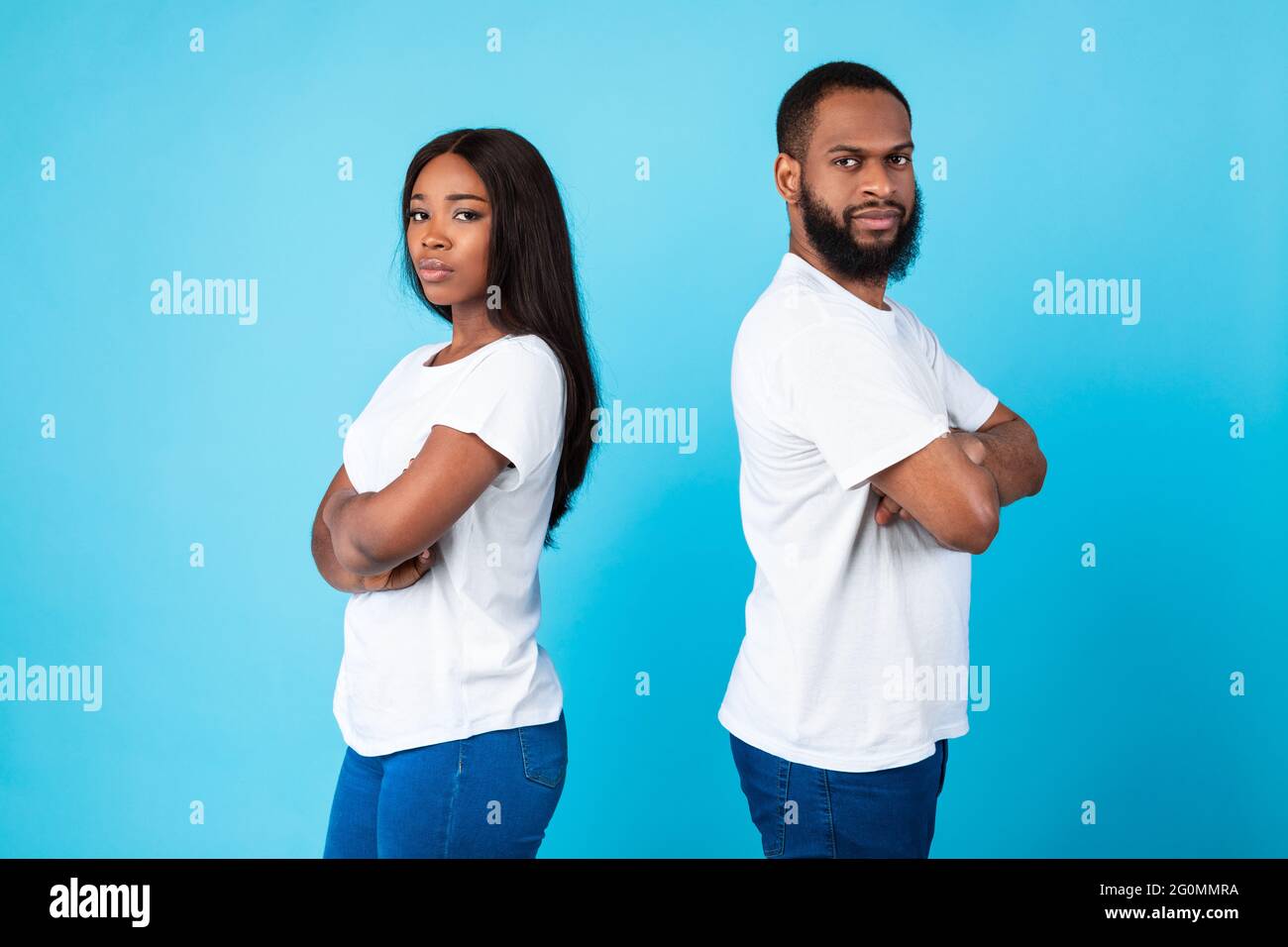 Afro coppia in piedi indietro, sfondo blu studio Foto Stock