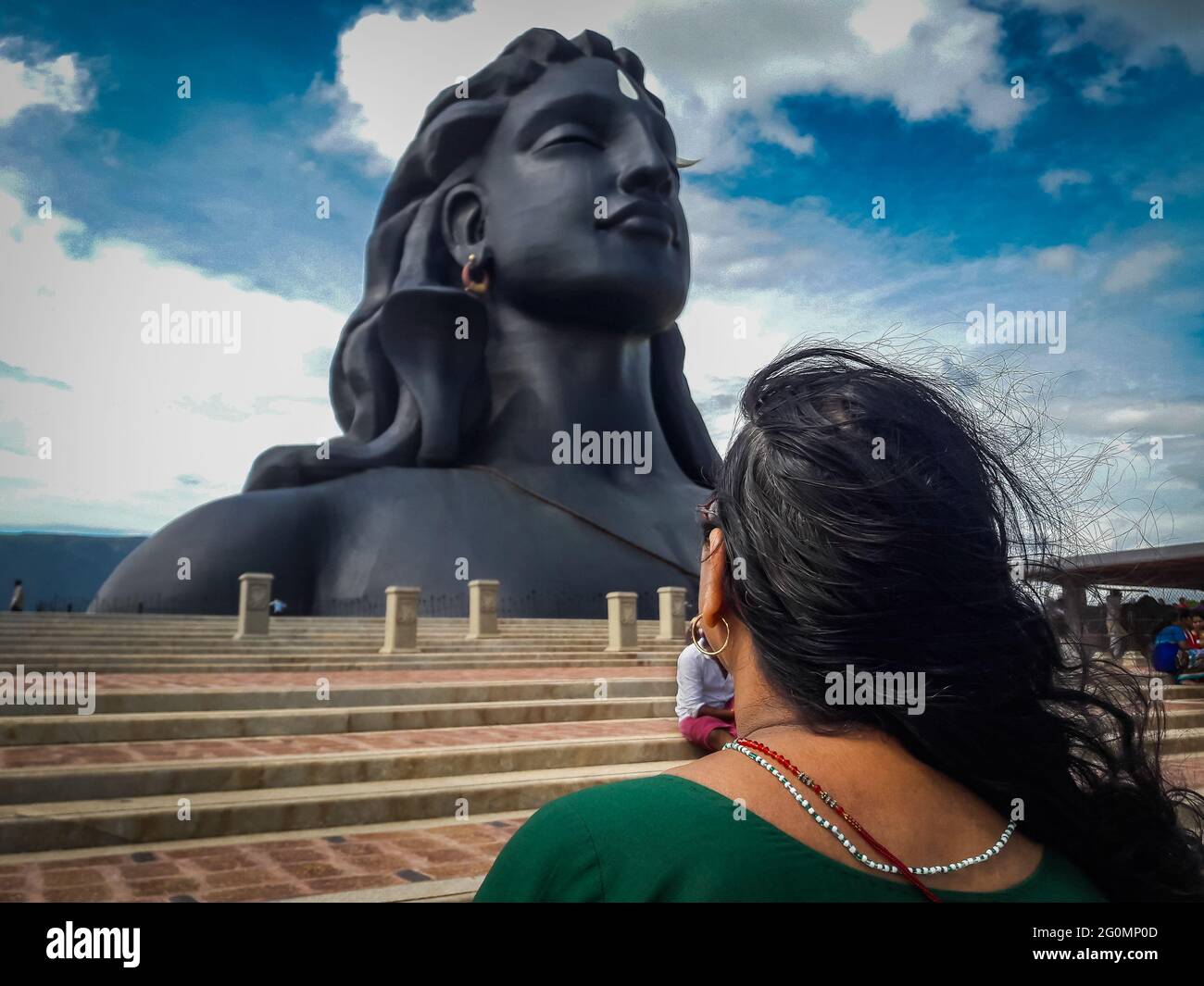 Devoto che paga il salutaion all'adiyogi shiva in yog asnam l'immagine è presa a coimbatore india che mostra la statua del dio in montagna e sullo sfondo del cielo. T Foto Stock