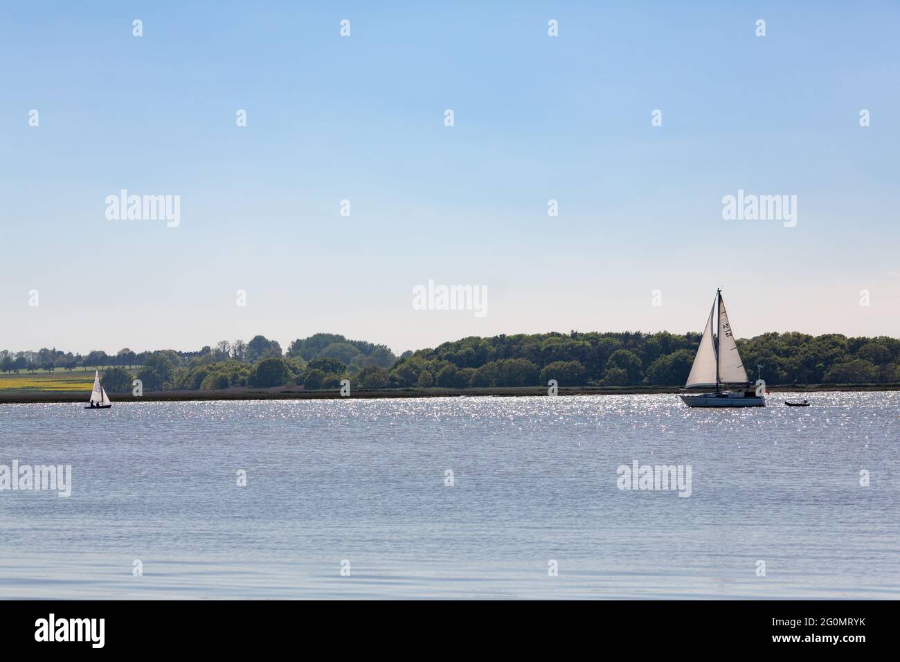 Woodbridge, Suffolk, UK 29 2021 maggio: Un grande yacht e una piccola barca a vela sul fiume Deben Foto Stock