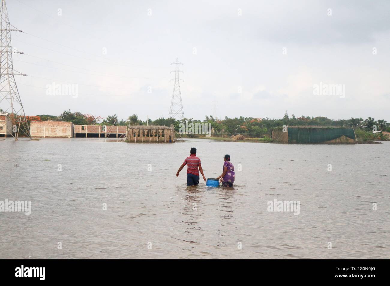Dopo che il ciclone Yaas ha fatto la sua caduta a Orissa e regioni costiere adiacenti il 26 maggio 2021 diverse aree di Sunderban rimangono sommerse, costringendo la gente a huddle nei rifugi del ciclone o a trascorrere giorni sulle terrapieni. Una volta che l'acqua di mare entra nelle isole, non solo le unità abitative vengono distrutte, ma le colture vengono inondate e la terra non può essere coltivata a causa della salinità, anche i pesci negli stagni muoiono. Diversi fiumi che passano attraverso fluiscono sopra il livello di pericolo e con acqua che sgorga in molti villaggi in zone come Hingalganj, Gosaba e Namkhana, distretto di Patherpratima. Le fotografie in Foto Stock