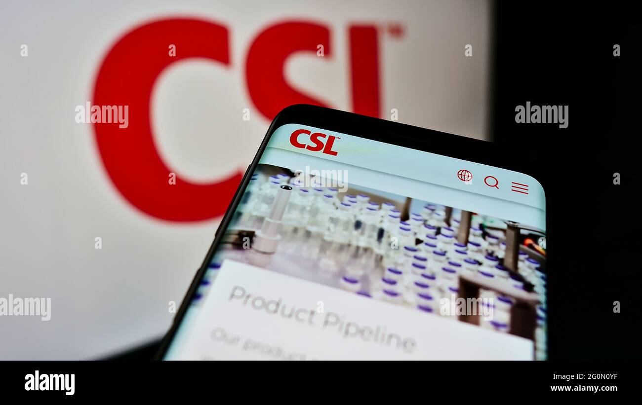 Smartphone con pagina web della società farmaceutica australiana CSL Limited sullo schermo davanti al logo aziendale. Mettere a fuoco in alto a sinistra del display del telefono. Foto Stock