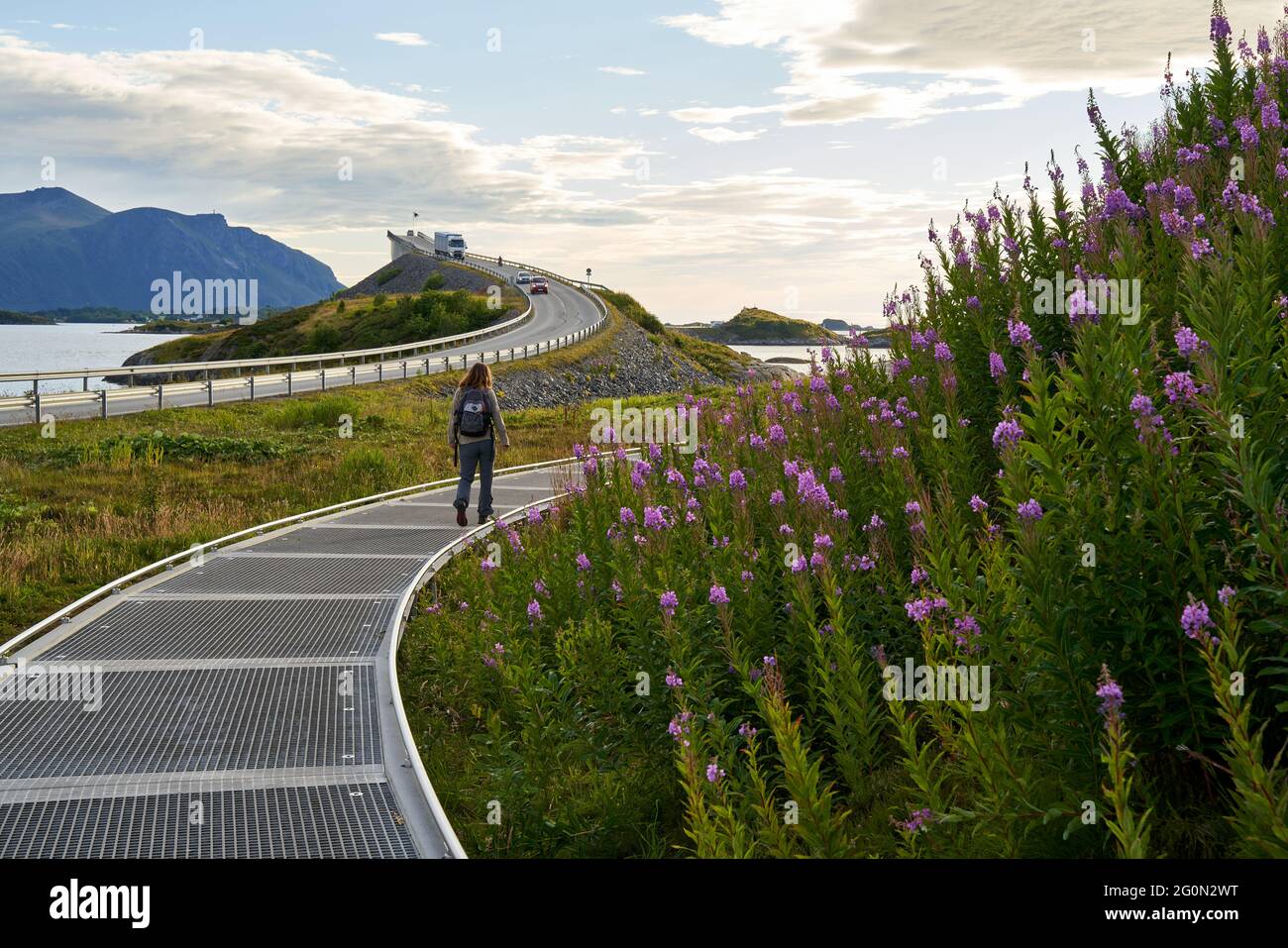 VEVANG, NORVEGIA - 28 luglio 2020: Una donna è a piedi vicino al Ponte Storseisundet e la strada Oceano Atlantico in Norvegia Foto Stock