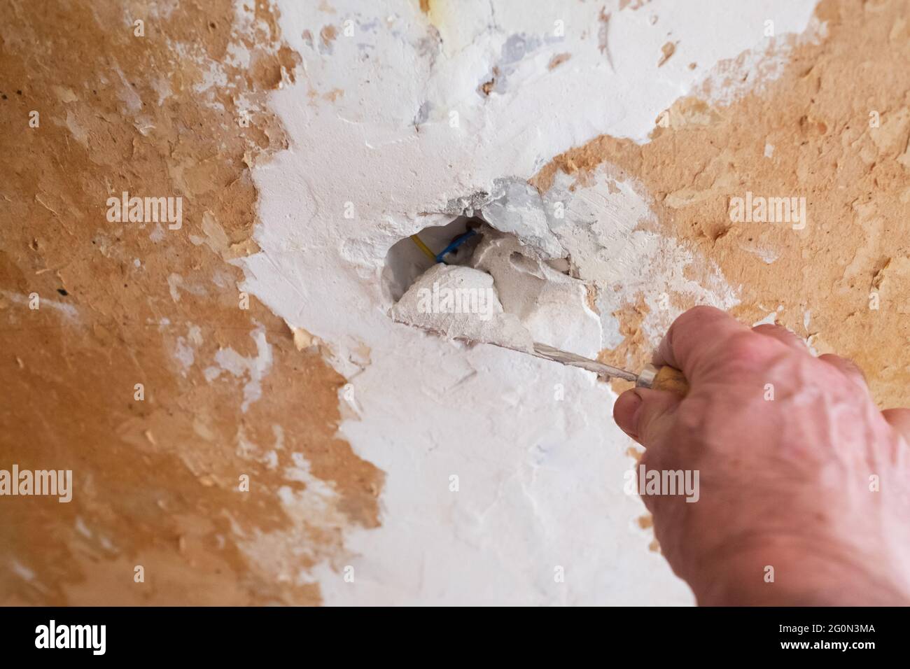 Riparazione del muro - uomo che mette la staffa su un buco nel muro Foto Stock