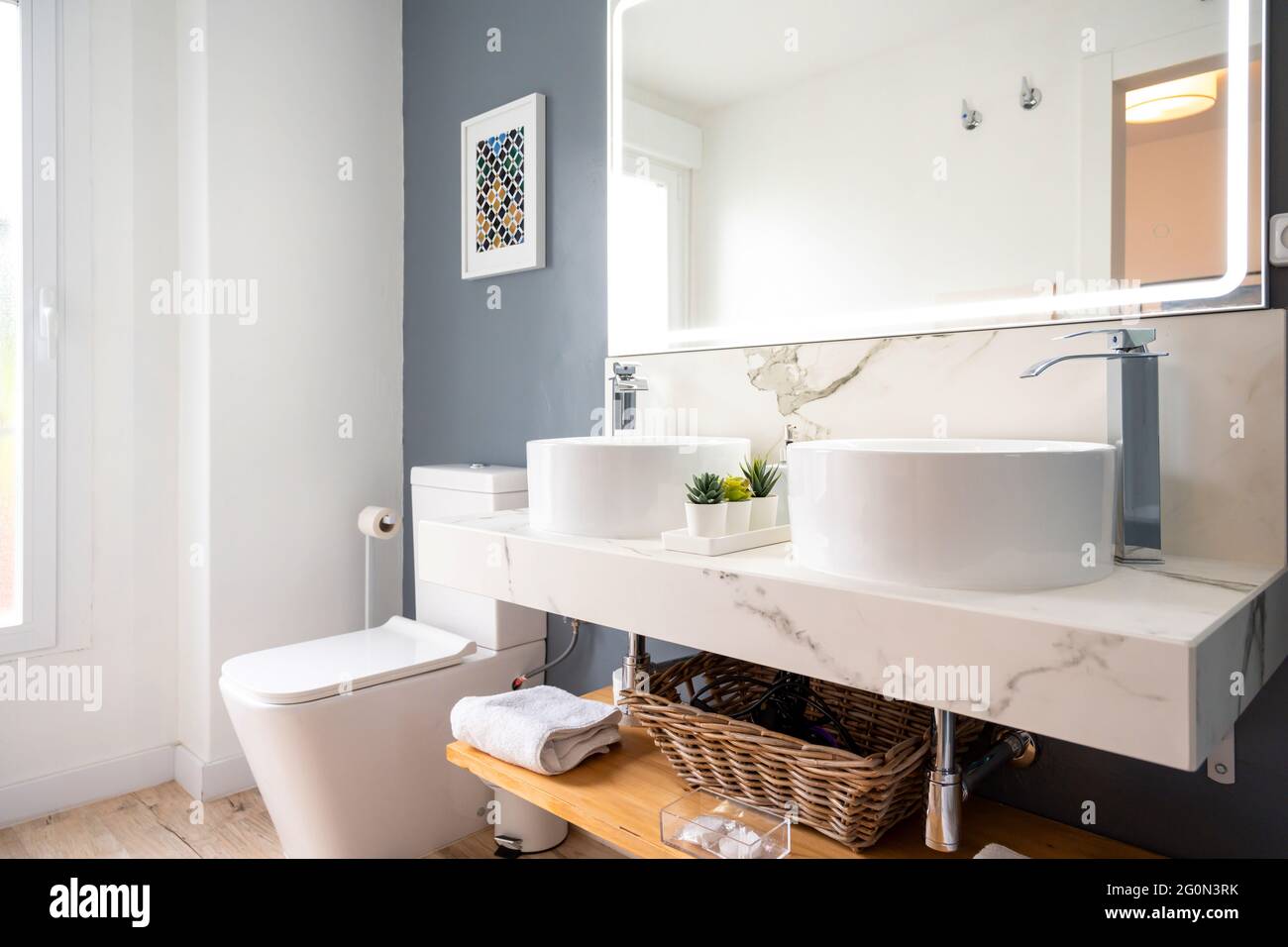Interno di bagno luminoso e moderno con specchio con luce Foto Stock