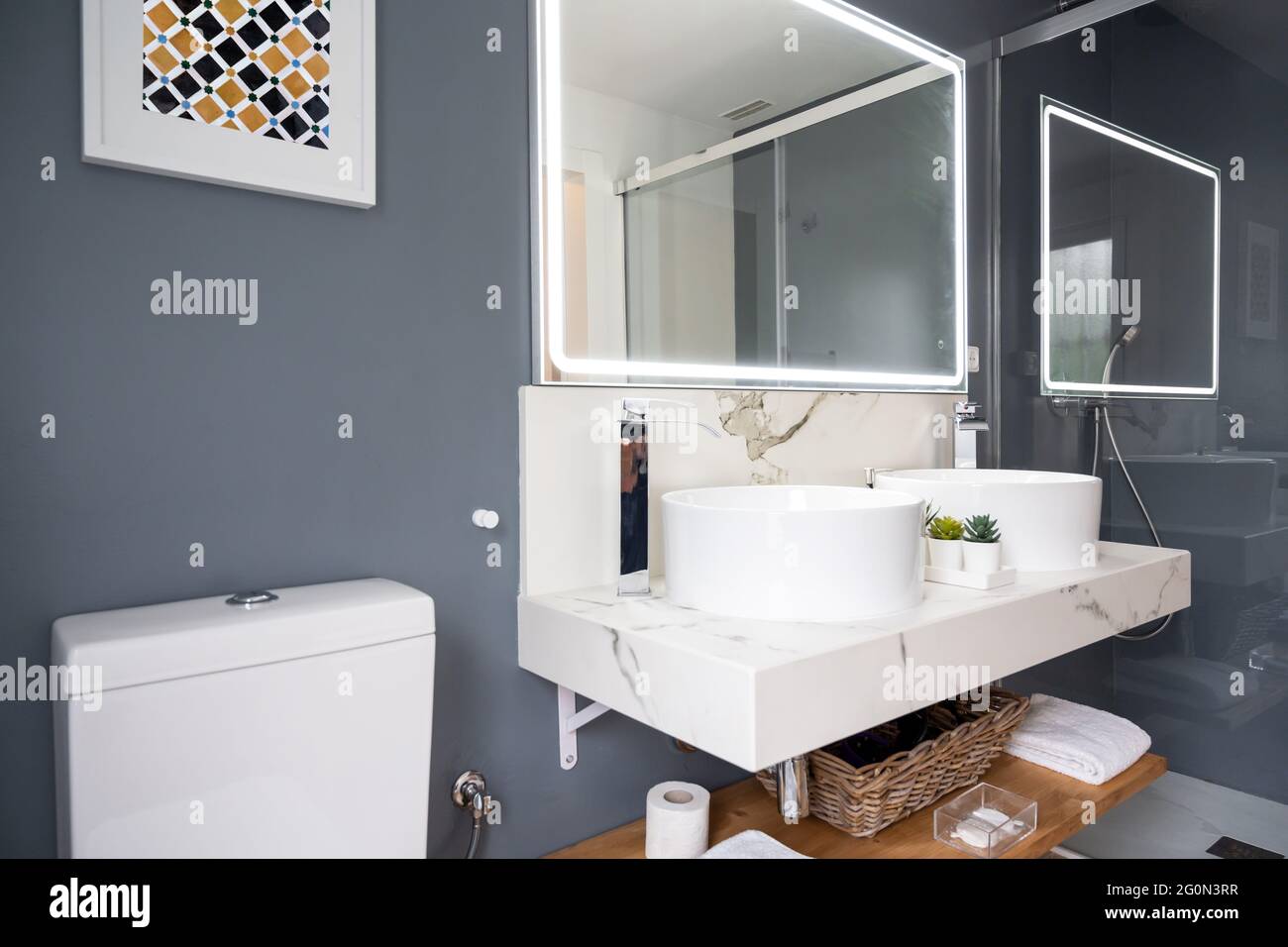 Interno di bagno luminoso e moderno con specchio con luce Foto Stock